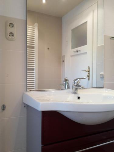 德累斯顿Ferienwohnung Dresden West的浴室设有白色水槽和镜子