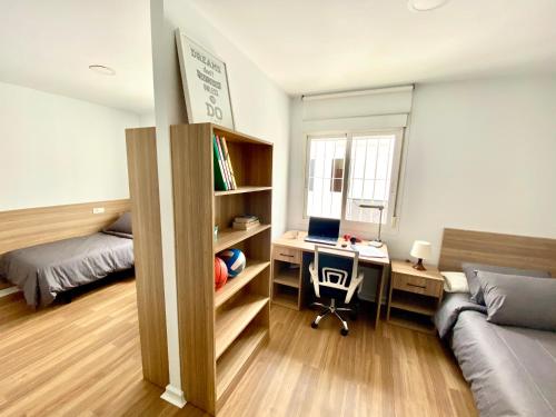 马拉加Micampus Málaga的一间卧室配有一张床和一张带笔记本电脑的书桌