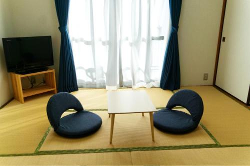 高知Apartment in Kochi-Vacation STAY 84284的客厅配有两张蓝色椅子和一张桌子