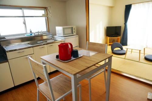 高知Apartment in Kochi-Vacation STAY 84284的厨房配有红色用具的桌子