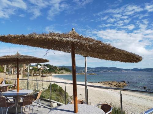 阿瑞斯A Postiña的海滩上的一张桌子和一把遮阳伞