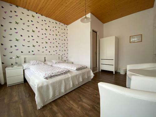 因特拉肯阿尔皮纳酒店的一间卧室设有两张床,墙上设有蝴蝶。