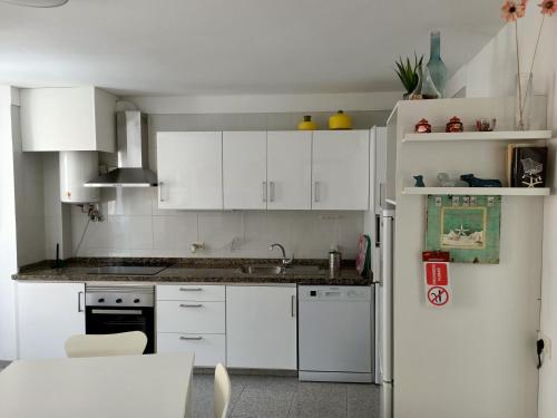 格拉纳迪利亚德亚沃纳Casa Mary的厨房配有白色橱柜和白色冰箱。
