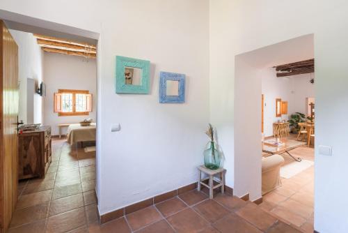 圣埃乌拉利亚Casa rural es Murtà的一间客厅,配有白色的墙壁和一张桌子上的花瓶