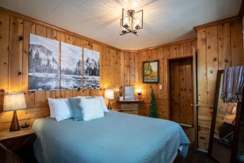 六月湖湖滨小屋酒店的一间卧室设有蓝色的床和木墙