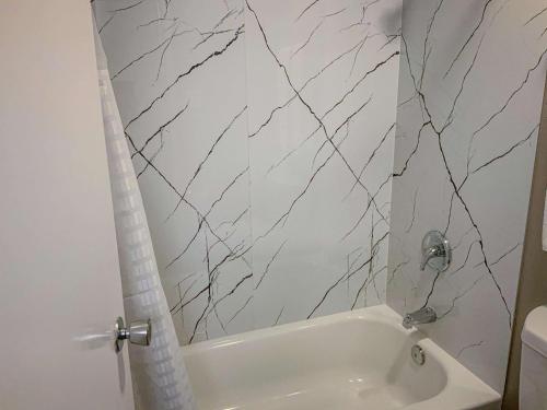 圣安吉洛圣安吉洛美国最佳价值酒店的浴室配有白色浴缸和大理石墙壁。