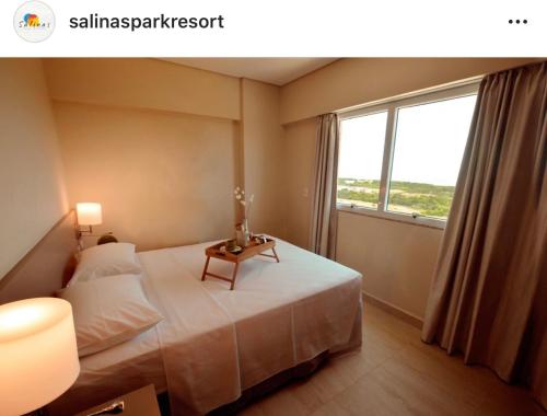 萨利诺波利斯Salinas Parks的一间卧室配有一张带桌子和窗户的床