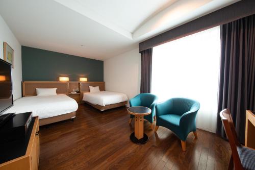 名古屋名古屋花园皇宫酒店的酒店客房设有两张床和电视。