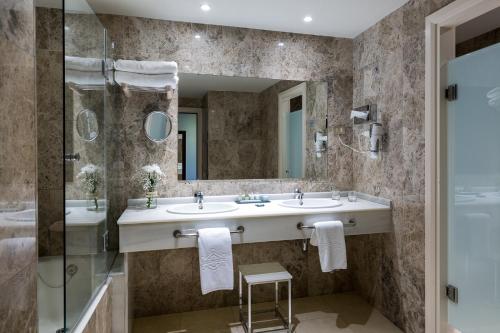 希洪希洪旅馆的浴室设有2个盥洗盆、淋浴和镜子。