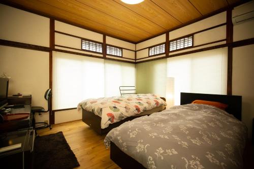 东京Kitazawa Cozy House的一间带两张床的卧室,位于带窗户的房间内