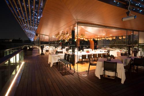 贝加莫圣马可高级酒店的一间晚上在甲板上摆放桌椅的餐厅