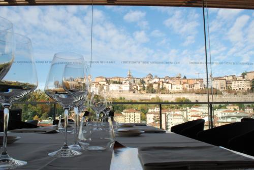 贝加莫圣马可高级酒店的一张桌子,桌子上摆放着酒杯,享有美景