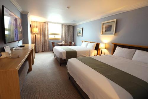 釜山普瑞玛观光酒店的酒店客房设有两张床和电视。