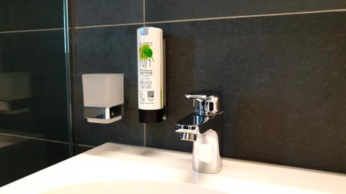 KürnachWÜ Hotel by WMM Hotels的浴室水槽和墙上的肥皂分配器