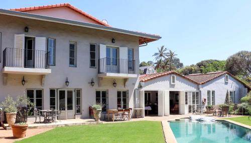 德班Maison H Guest House的一座带游泳池和庭院的房子
