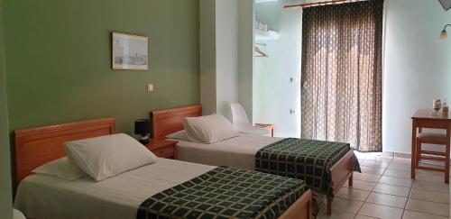 埃尔莫波利斯Zannikos Rooms的酒店客房设有两张床和窗户。