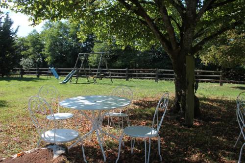 莫尔塔涅欧佩什Roulotte Poulette的公园内的一张桌子、两把椅子和秋千