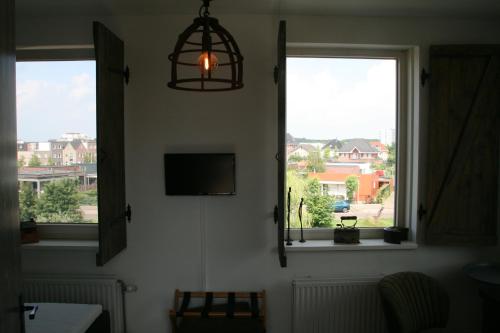 阿尔梅勒B&B Het kasteel的客房设有2扇窗户和1台平面电视。