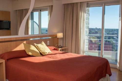 巴拉那马兰白套房酒店的一间卧室设有一张大床和大窗户