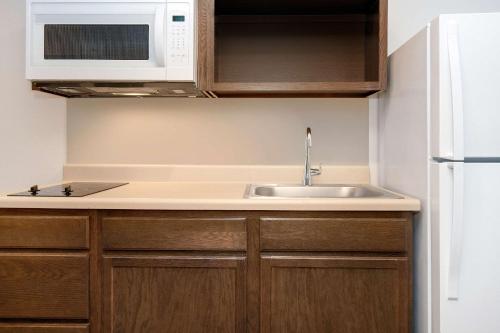 罗斯奇姆WoodSpring Suites Carol Stream - Chicago的厨房配有水槽和微波炉