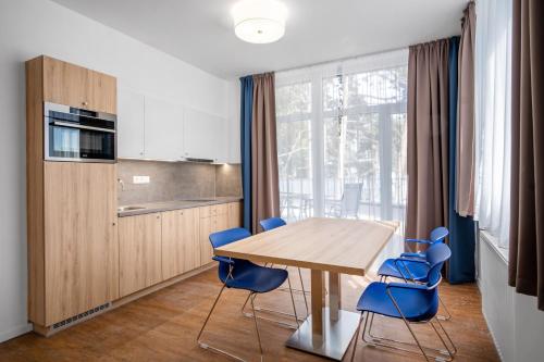 希欧福克Szent Bernadett Családi Apartmanház的厨房配有木桌和蓝色椅子