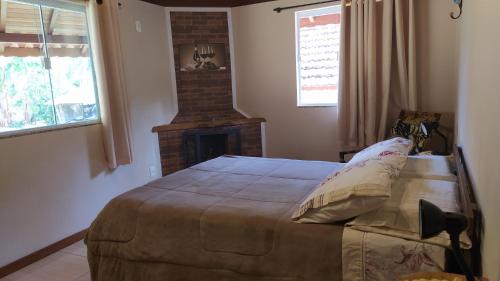 维奥康德马奥Casa do Osorio的一间卧室设有一张大床和一个壁炉