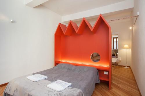 曼托瓦Casa Iolanda的一间设有一张橙色墙壁的床的房间
