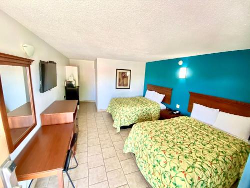 罗斯威尔Budget Inn的酒店客房配有两张床和一张书桌