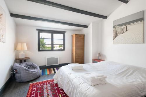 圣马丹德雷Appartement Bastingage的卧室配有白色的床和红色地毯。