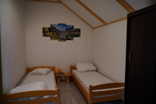 PerlejewoAgroturystyka Witoldówka的一间设有两张床的客房,墙上挂着一张照片