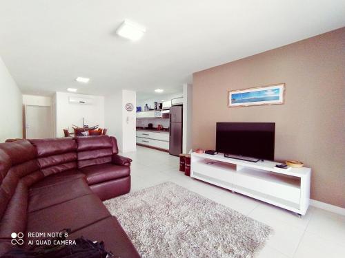 弗洛里亚诺波利斯Marine Home Resort- piscina aquecida-hidromassagem的带沙发和平面电视的客厅