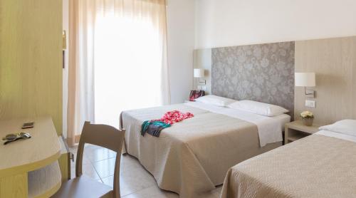 里米尼雷登斯酒店的酒店客房设有两张床和窗户。