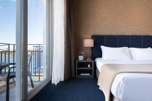 斯利马Waterfront的酒店客房设有一张床和一个阳台。