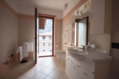 滕诺Castel View Apartment - Gardaslowemotion的一间带水槽和卫生间的浴室以及窗户。