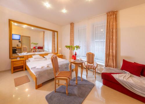 尤斯托尼莫斯基Murena Hotel i Restauracja的一间卧室配有一张床、一张桌子和一面镜子