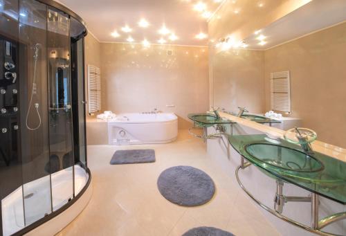 尤斯托尼莫斯基Murena Hotel i Restauracja的浴室配有两个玻璃水槽和一个浴缸。
