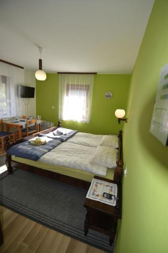 博希尼Guest House Žnidar的一间卧室配有一张带绿色墙壁的床和一张桌子