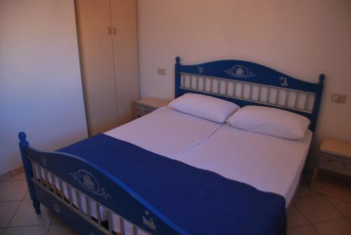 罗索利纳马雷Acquasmeralda appartamento 01的卧室配有蓝色和白色的床和2个枕头
