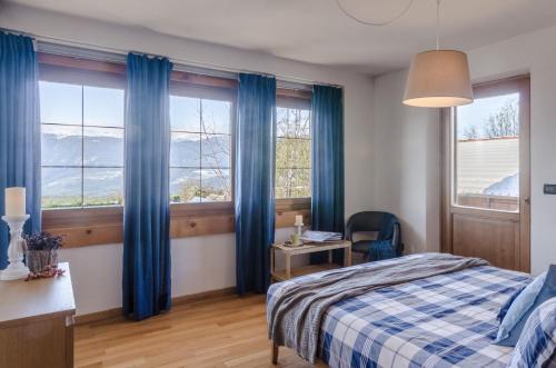 罗恩佐Villa Recla的一间卧室配有蓝色窗帘和一张带书桌的床