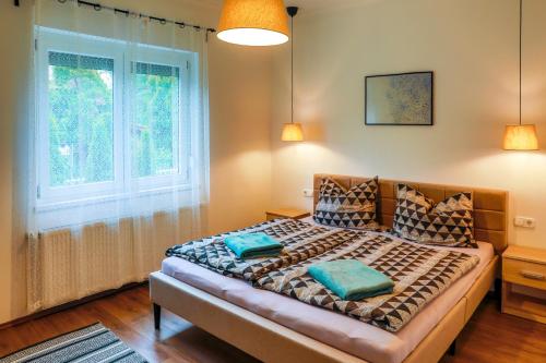 巴拉通马里亚弗都Villa Bárdió的卧室配有带枕头的床铺和窗户。