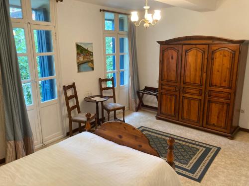 塞雷Poppys Chambres d'Hotes的一间卧室配有一张床和一个木制橱柜