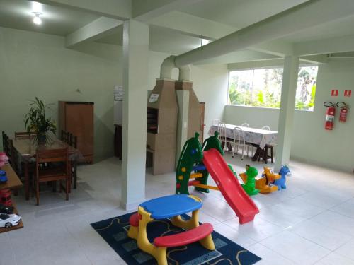 乌巴图巴Praialar Apartamentos Ubatuba的一个带滑梯和玩具的游戏室