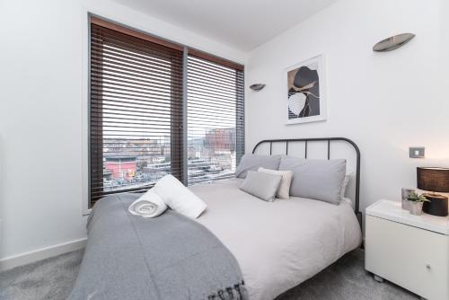 泰恩河畔纽卡斯尔Newcastle Penthouse - Sleeps 8 - City Centre - Free Parking - City Views的卧室配有白色的床和大窗户