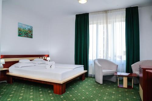 克卢日-纳波卡Hotel Pami的配有一张床和一把椅子的酒店客房