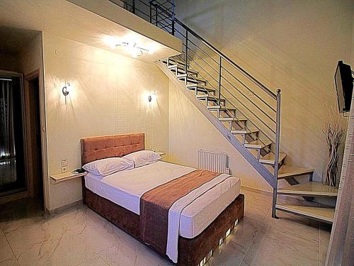 尼基季Sky Rays Luxury Apartments的一间卧室设有一张床和一个螺旋楼梯