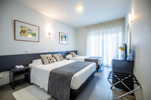 博利凯梅Boutique & Villas Boliqueime的酒店客房设有两张床和电视。
