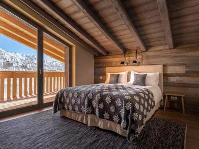 布勒伊-切尔维尼亚拉克雷斯塔木屋酒店的一间卧室设有一张床和一个大窗户