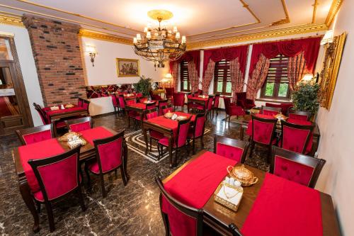 卡尔斯Hotel Katerina Sarayı 1877的餐厅设有红色的桌椅和吊灯