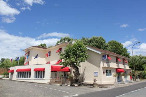 ArjuzanxHôtel du Lac d'Arjuzanx的街上有红色遮阳篷的建筑
