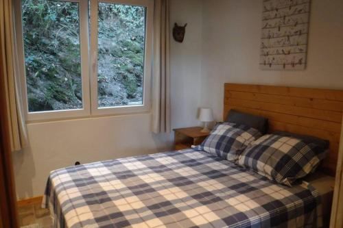 维安登The Vianden Cottage - Charming Cottage in the Forest的一间卧室设有一张床和两个窗户。